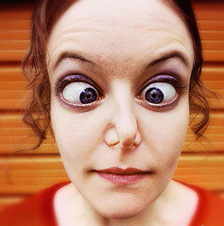 closeup of cross-eyed woman with nostrils pinched shut