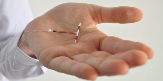 Holding an IUD birth control device in hand