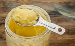 jar and measuring tablespoon of ghee - clarified butter
