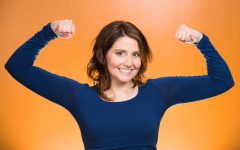 Closeup portrait beautiful, pretty model woman flexing muscles showing, displaying her strength, isolated orange background. Positive human emotions, facial expressions, feelings, attitude, perception