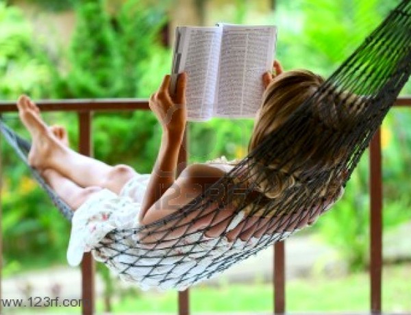 young-woman-reading-a-book-lying-in-a-hammock
