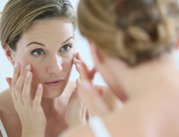 Middle-aged woman applying anti-aging cream