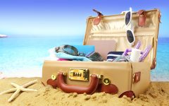 Full open suitcase on tropical beach background